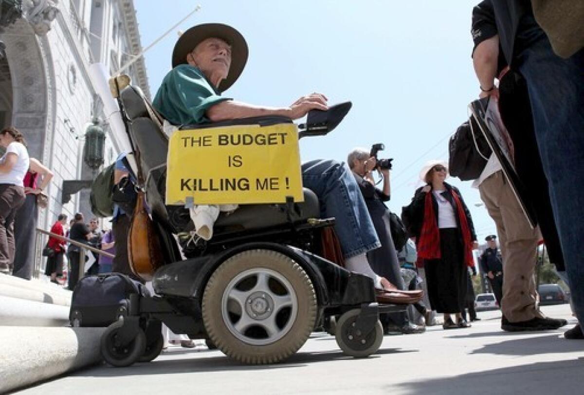 In San Francisco, a man in a wheelchair protests proposed budget cuts.