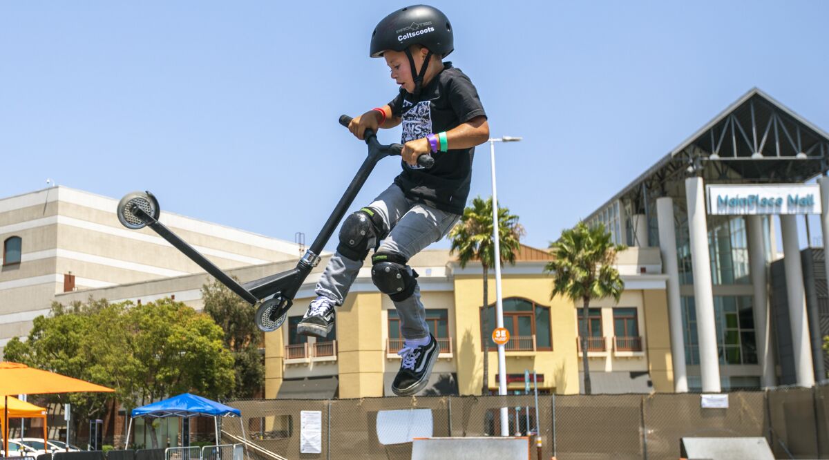 A boy flies in the air on his scooter