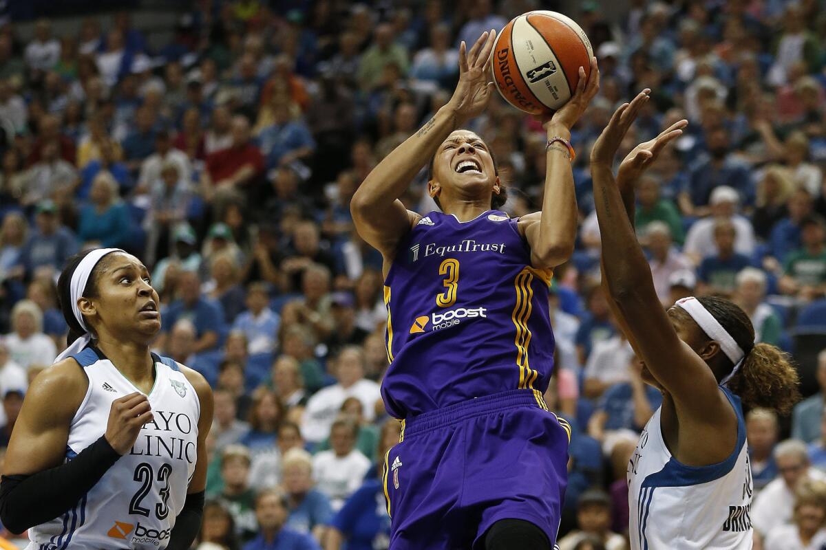Sparks forward Candace Parker goes up for a shot past Minnesota Lynx forwards Maya Moore (23) and Rebekkah Brunson during the first half of Game 3 of a WNBA Western Conference semifinals.