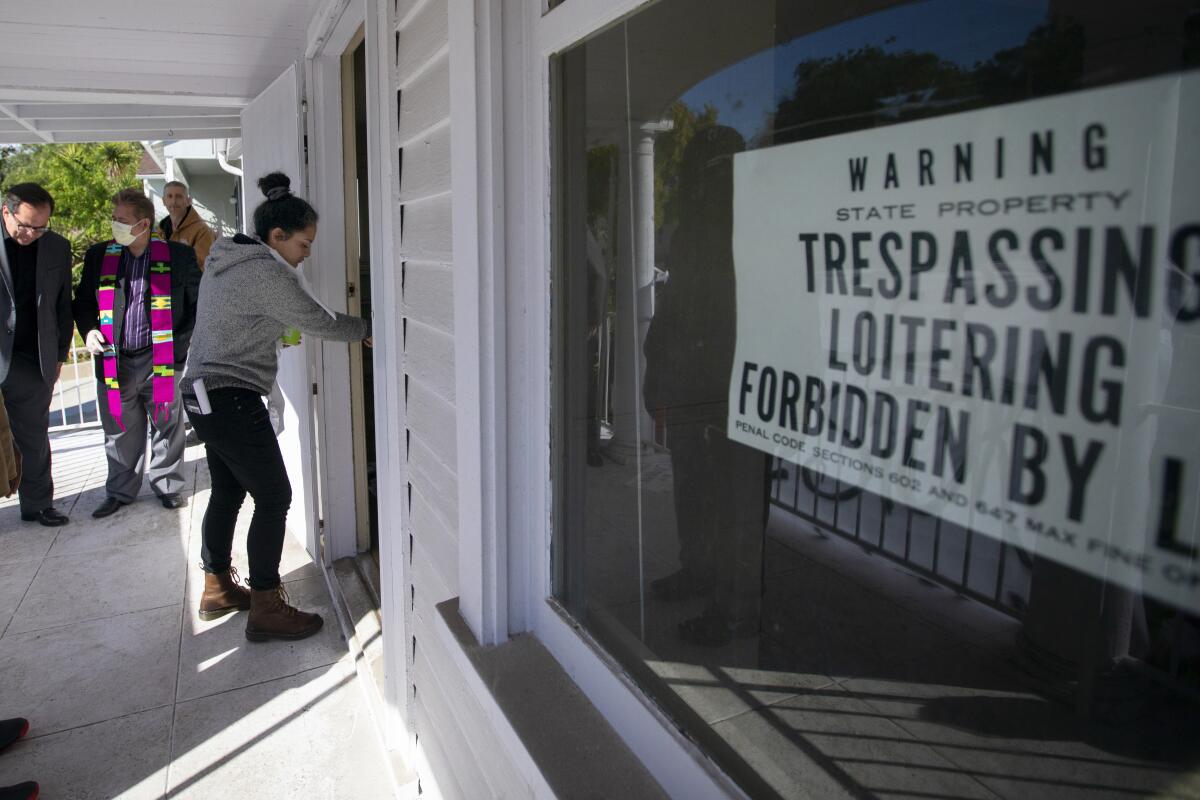 A woman lets herself into a Caltrans-owned home in El Sereno in March 2020 as part of the Reclaimer protests.