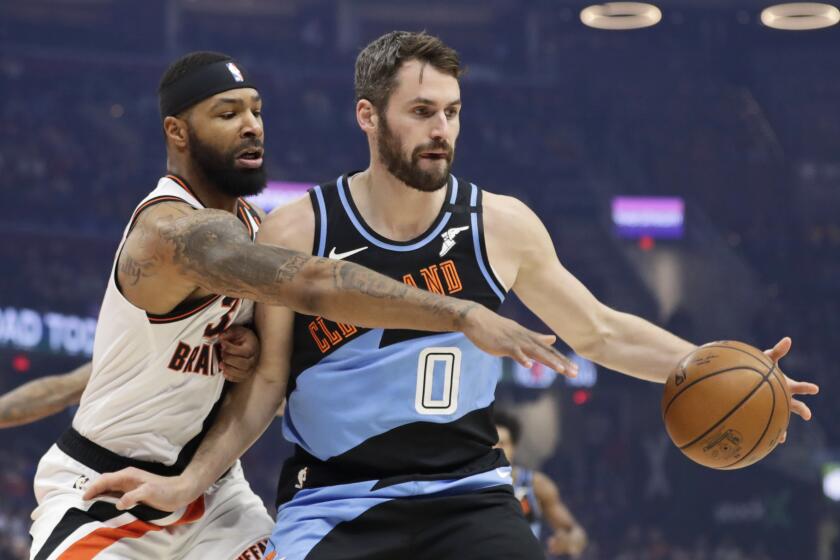 Los Angeles Clippers' Marcus Morris Sr., left, cannot knock the ball loose from Cleveland Cavaliers' Kevin Love in the first half of an NBA basketball game, Sunday, Feb. 9, 2020, in Cleveland. (AP Photo/Tony Dejak)