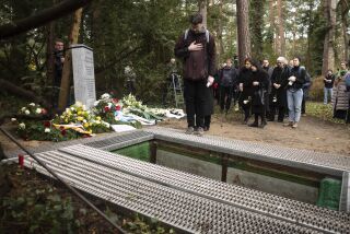 Personas se reúnen para el entierro de huesos terrenos de la Universidad Libre en Berlín, Alemania, el jueves 23 de marzo de 2023. (AP Foto/Markus Schreiber)