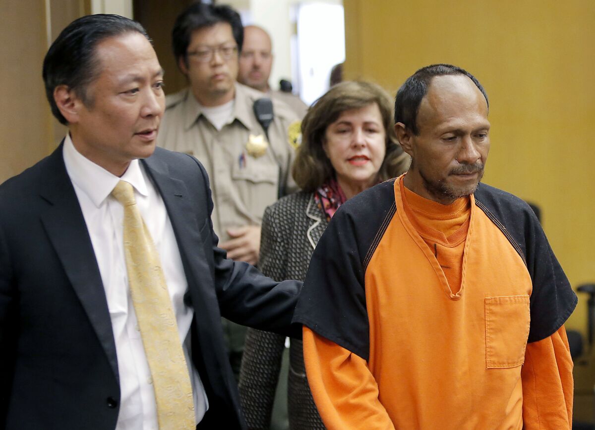 FILE - In this July 7, 2015 file pool photo, Juan Francisco Lopez-Sanchez, right, is lead into the courtroom by San Francisco Public Defender Jeff Adachi, left, and Assistant District Attorney Diana Garcia, center, for his arraignment at the Hall of Justice in San Francisco. A federal judge in San Francisco on Wednesday, Aug. 11, 2021, ordered a new mental health evaluation of Lopez-Sanchez, acquitted of murder in the 2015 fatal shooting of a woman on a city pier, a killing that became a national flashpoint over immigration. (Michael Macor/San Francisco Chronicle via AP, File)