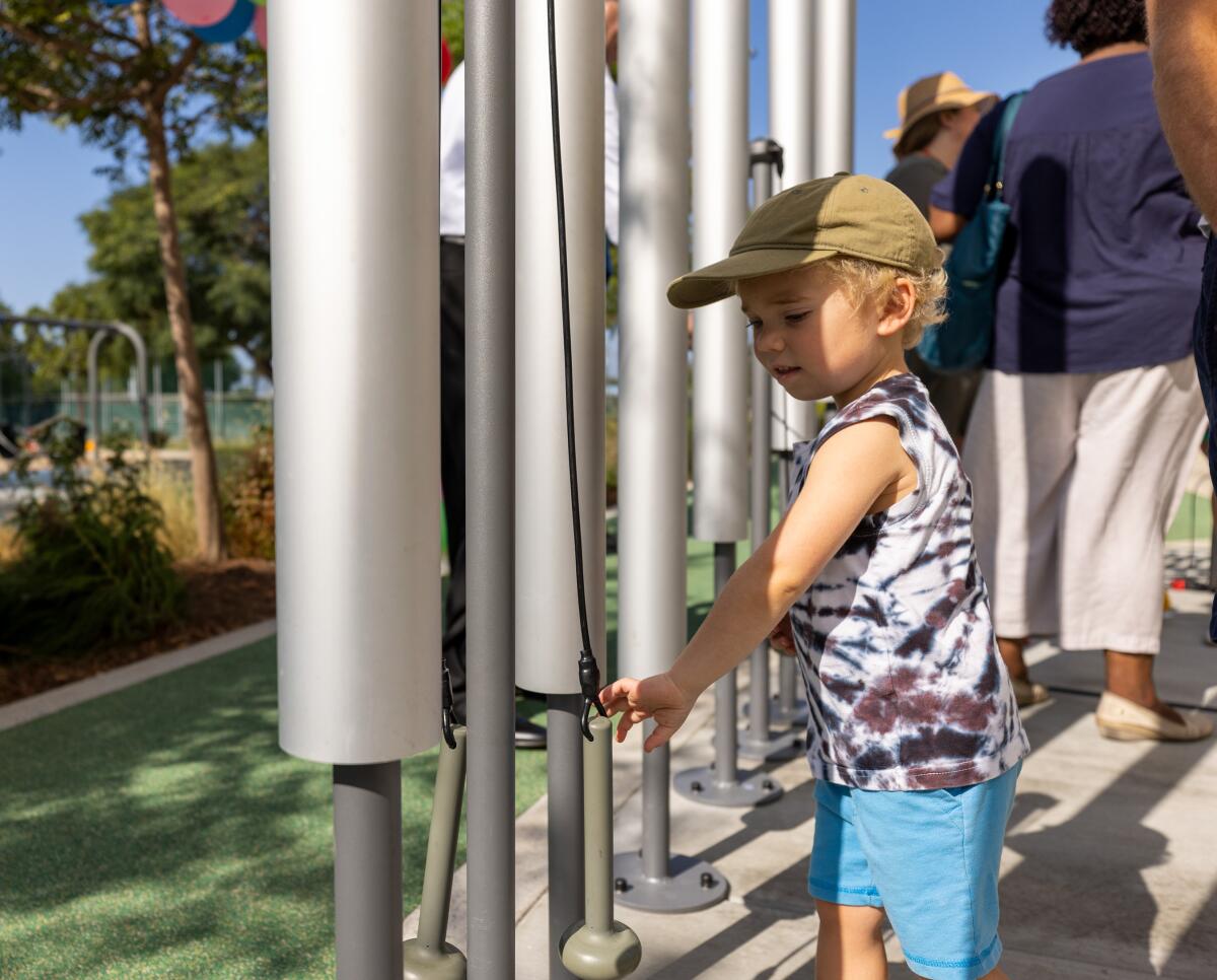 Mason Kelly plays with the new outdoor chime instrument outside of the Donald Dungan Library.