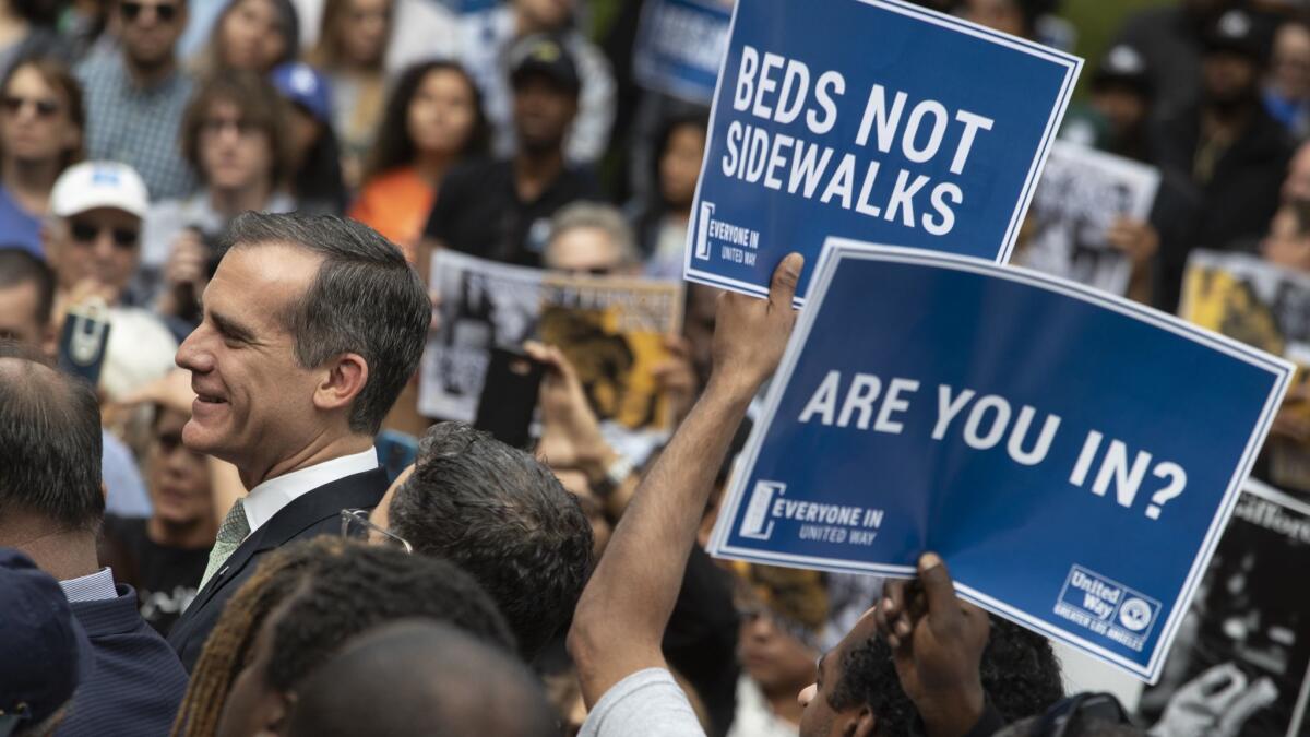 Los Angeles Mayor Eric Garcetti, left, joins people rallying at Los Angeles City Hall in support of temporary housing for the homeless on May 18.