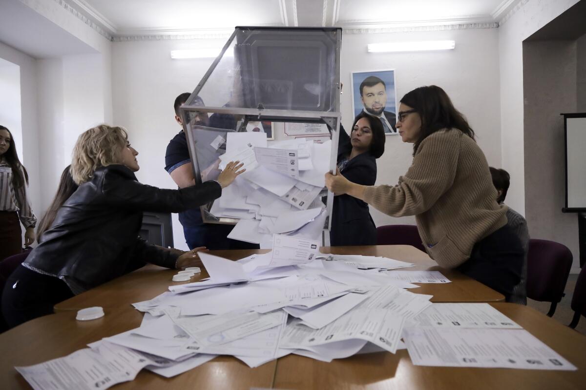 Election commission members preparing to count ballots at a table