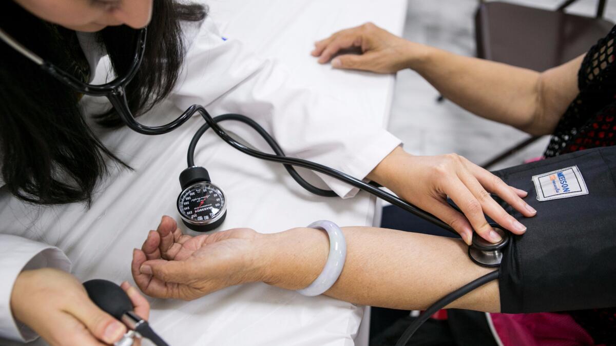 A physician checks a patient's blood pressure. A new study finds that a doctor's political views may influence the care he or she provides, especially when it comes to politically sensitive health issues such as abortion, marijuana use and firearm possession.