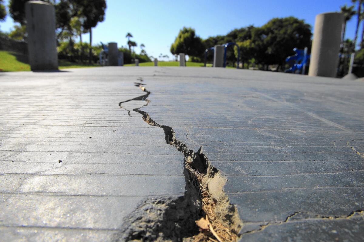 A long crack splits the sidewalk at 6.6-acre Discovery Well Park in Huntington Beach, located atop the Newport-Inglewood fault. Officials knew the fault would be an issue when they began drawing up plans that would bring thousands of new residents to the city.