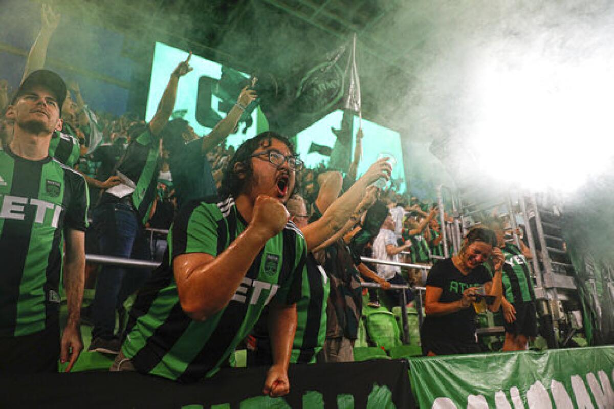 Austin FC fans celebrate by throwing water and beer in the air after the team scored its third goal against the Portland Timbers during an MLS soccer match Saturday, Aug. 21, 2021, in Austin, Texas. (Aaron E. Martinez/Austin American-Statesman via AP)