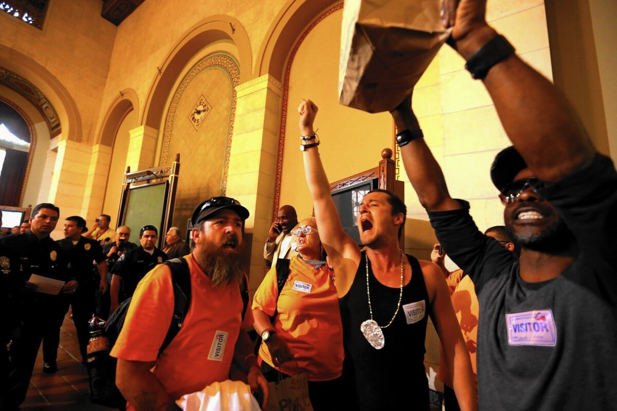 Members of the Los Angeles Community Action Network, a homeless advocate group, protest at City Council meeting where a crackdown on homeless encampments was approved.