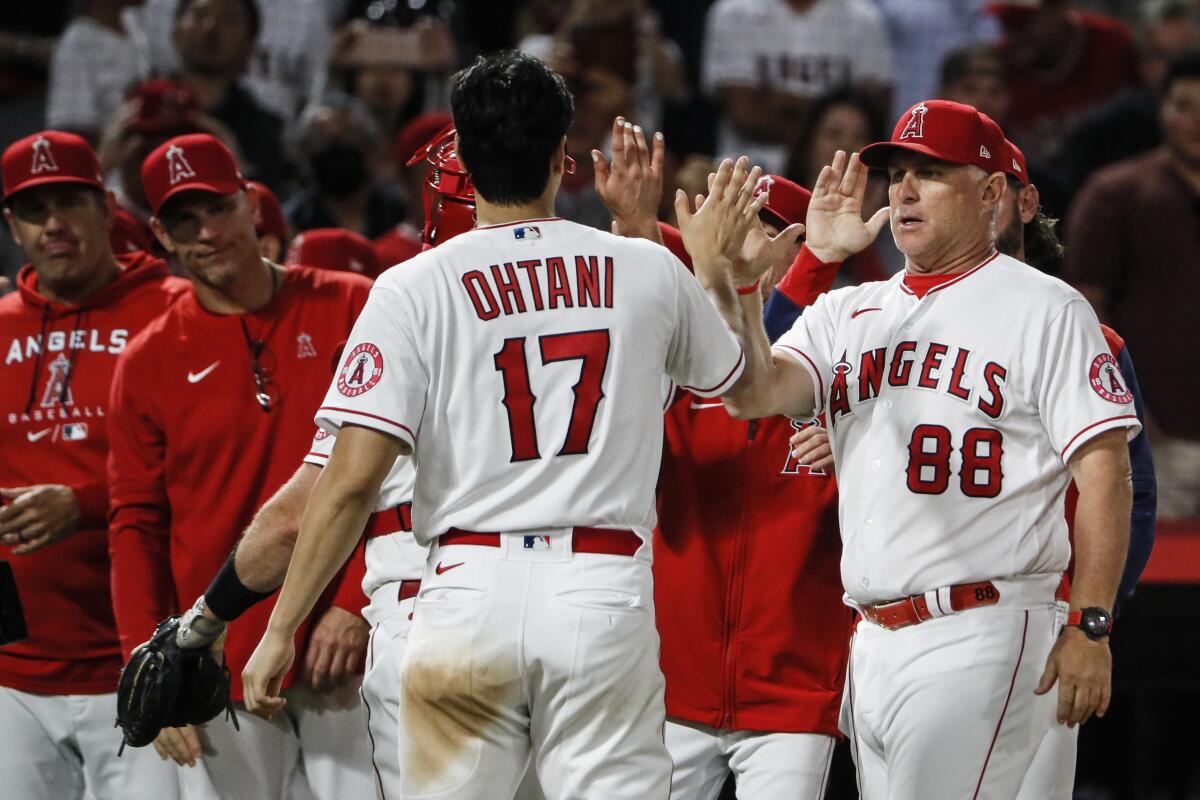 Angels manager Phil Nevin (88) congratulates Shohei Ohtani after a 7-1 victory over the Houston Astros on July 13, 2022.