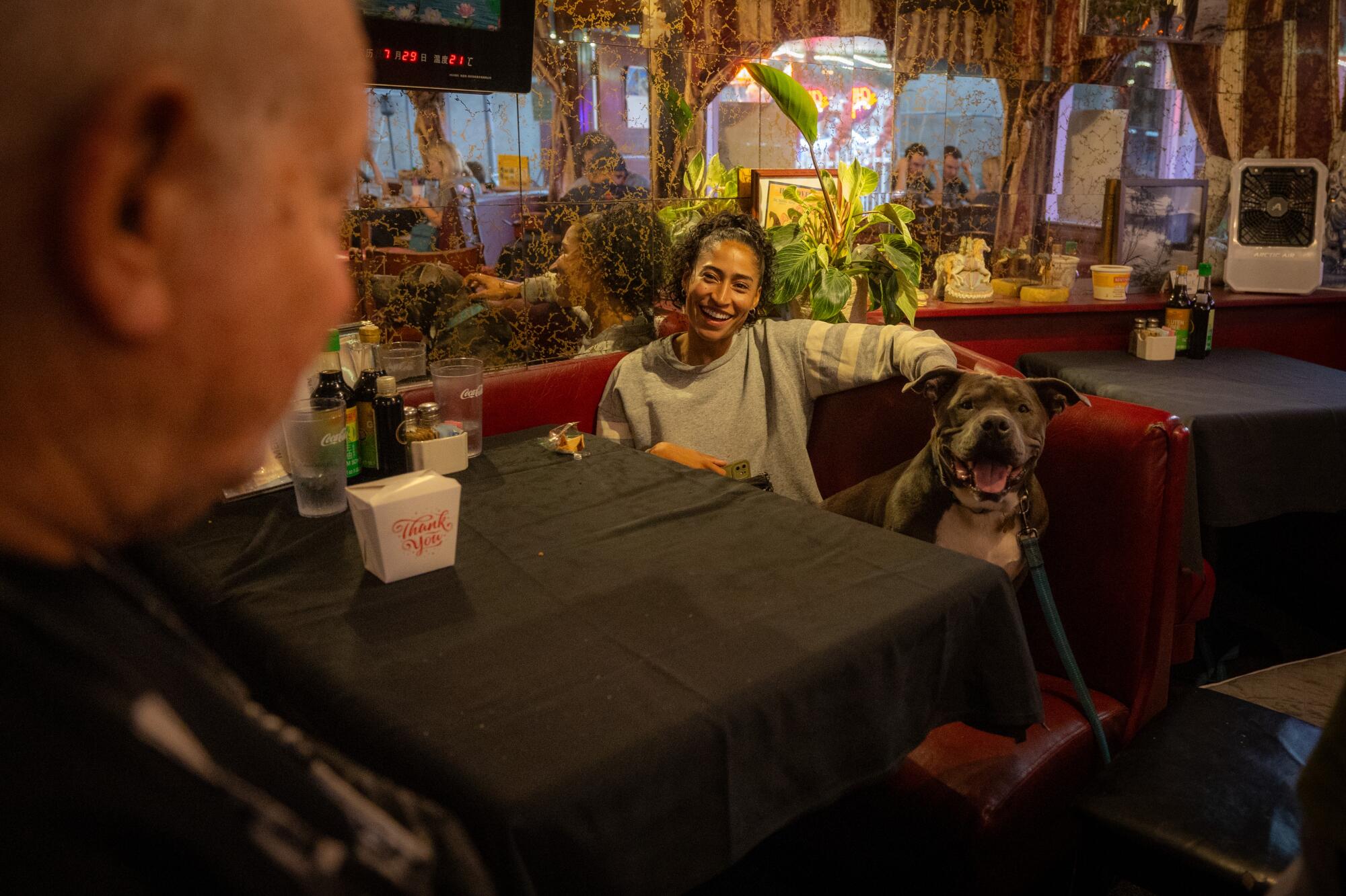 Dan Siegel's service dog, Blue, joins a customer in his stand.