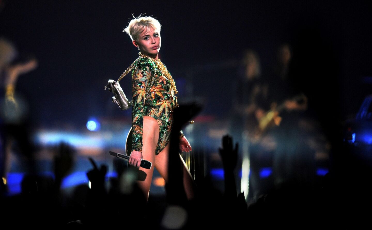 Miley Cyrus looks to the side as the bright lights catch a glimpse of her blond pixie cut.