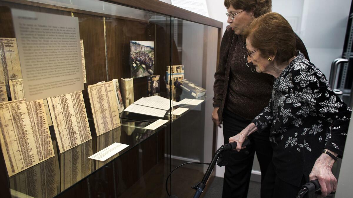 Ludmila Page, 96, one of the last survivors from Schindler's List, sees her name on the list while viewing the Oskar Schindler Archive for the first time at Chapman University. Her daughter, Marie Knecht, is on her right.