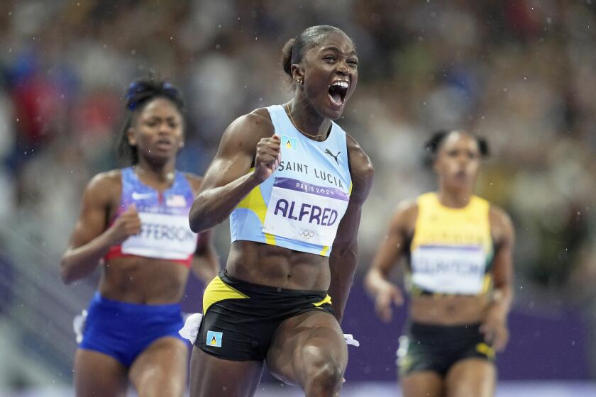 Julien Alfred, de Saint Lucía, celebra tras ganar la medalla de oro en los 100 metros del atletismo de los Juegos Olímpicos de París, el sábado 3 de agosto de 2024, en Saint-Denis, Francia. (AP Foto/Ashley Landis)