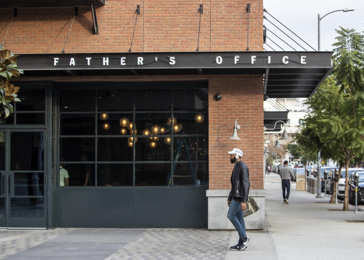 A man walks past the new Father's Office restaurant location in the Arts District.
