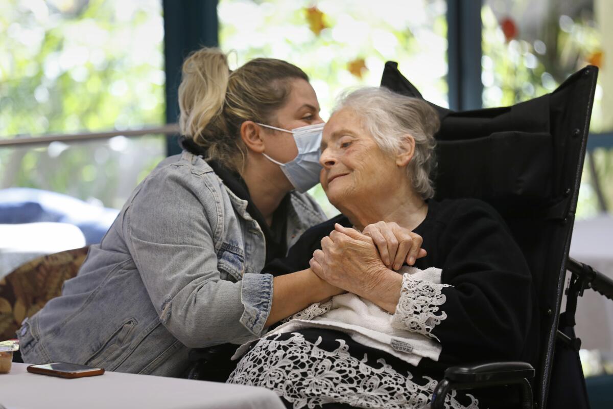 Ruzanna Grigoryan, left, visits her grandmother Anahit Papiryan at the Ararat Nursing Facility.