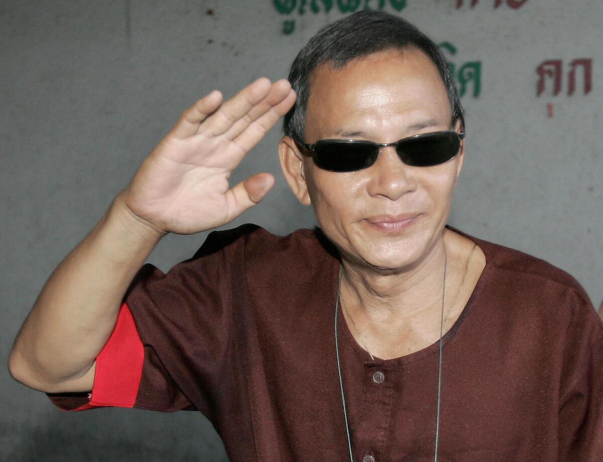 Former fighter pilot Ly Tong hijacked a plane flying from Thailand to Vietnam in 1992 to distribute thousands of leaflets calling for the overthrow of the communist government. Above, Tong waves as he arrives at court in Bangkok in 2006.