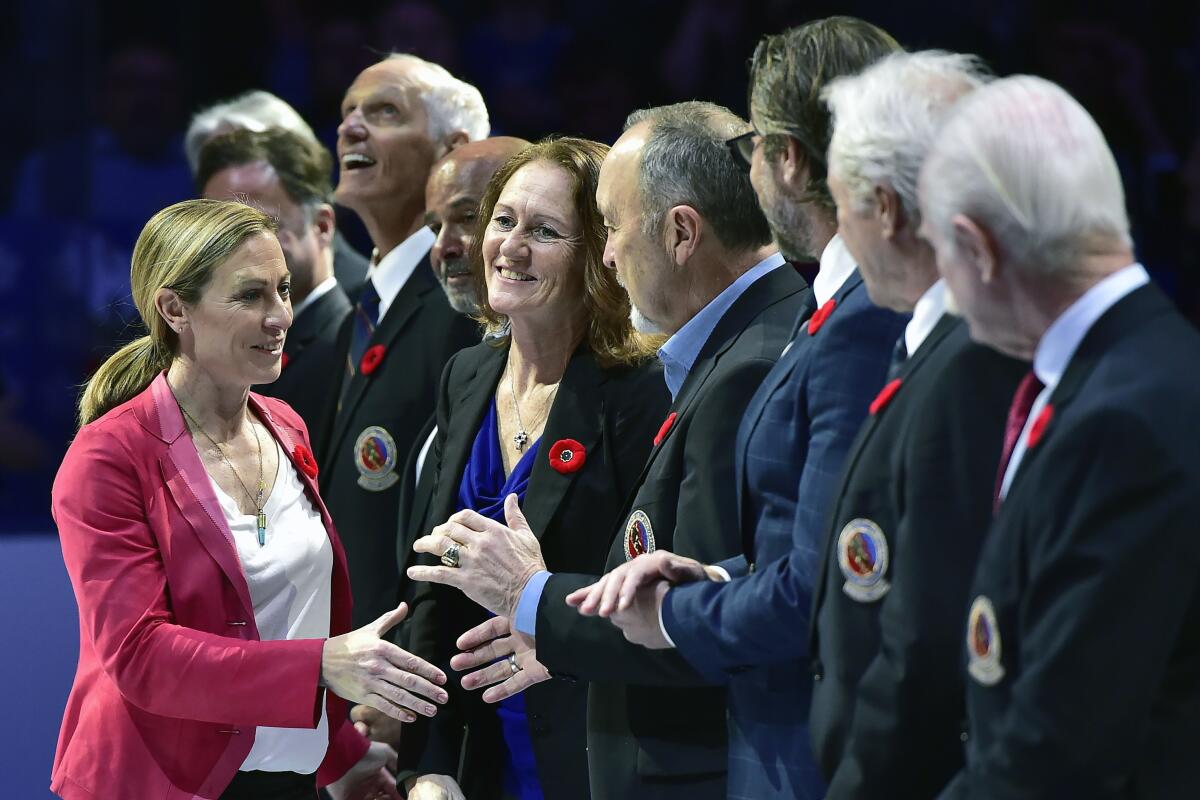 FILE - In this Nov. 9, 2018, file photo, Hockey Hall of Fame inductee Jayna Hefford shakes hands with people associated with the hall before a hockey game between the Toronto Maple Leafs and the New Jersey Devils in Toronto. The Professional Women’s Hockey Players’ Association is forging ahead in its bid to establish an economically sustainable professional league in North America with or — for now — without the NHL’s full financial backing. In response to Sportsnet.ca reporting the NHL was not in a position to operate a women’s league for the foreseeable future, PWHPA executive Jayna Hefford wrote in an email to The Associated Press late Thursday that her group has begun developing what she called “a parallel path for a future that doesn’t rely on NHL support.” (Frank Gunn/The Canadian Press via AP, File)