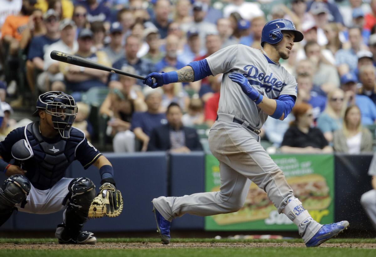 Dodgers catcher Yasmani Grandal hits a two-run single during the sixth inning against the Brewers. Grandal also hit a pair of three-run homers for an eight-RBI day.