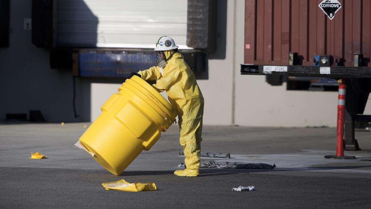 A member of the hazardous materials response team assists in cleaning up a chemical spill at Starkist Foods in Mira Loma that injured 16 people.