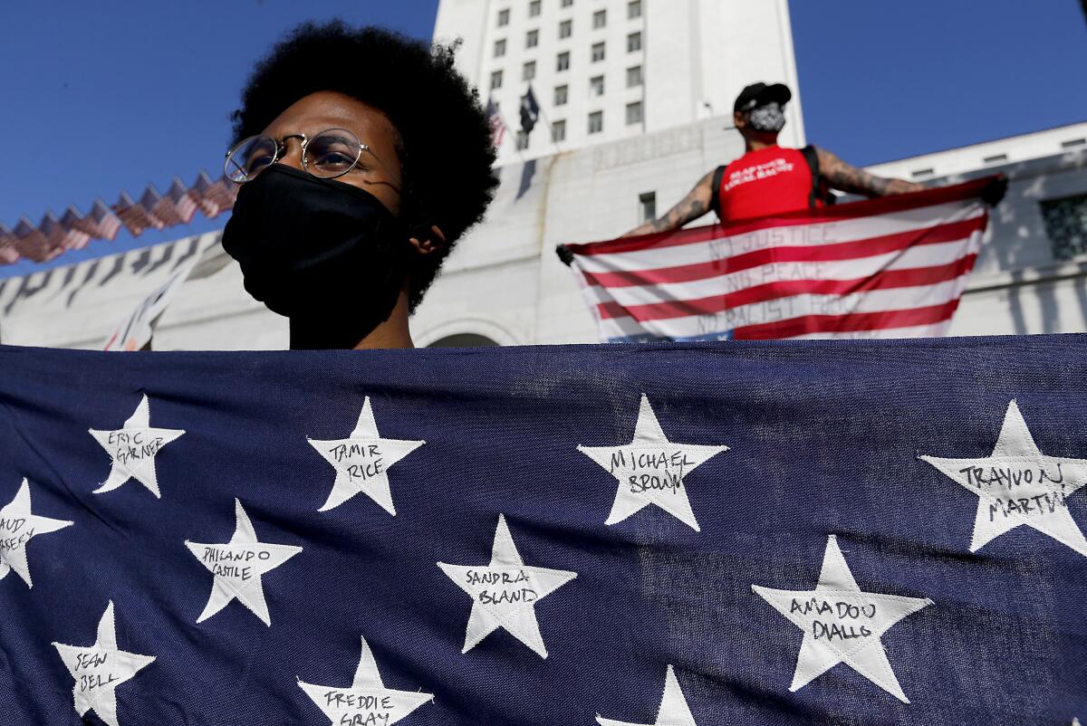 A protester holds a flag with the names of victims of violence during a demonstration June 4 in downtown Los Angeles.
