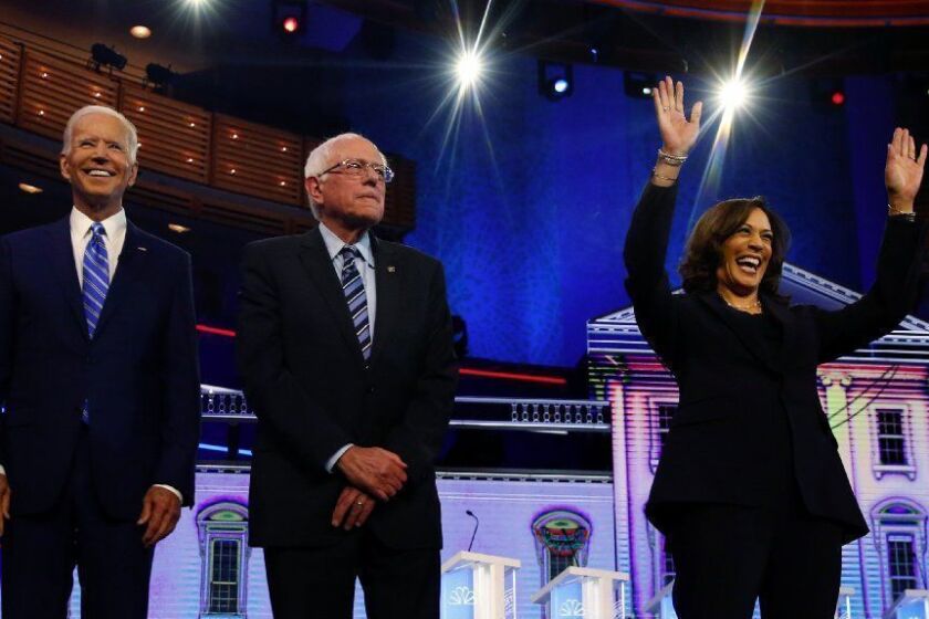 Democratic presidential candidates former vice president Joe Biden, left, Sen. Bernie Sanders, I-Vt., and Sen. Kamala Harris, D-Calif., right, stand on stage for a photo op before the start of the the Democratic primary debate hosted by NBC News at the Adrienne Arsht Center for the Performing...