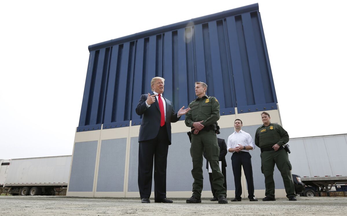 President Trump tours the border wall prototypes near the Otay Mesa Port of Entry in San Diego County on March 13, 2018. At right is Rodney Scott, chief patrol agent of the San Diego Sector of the Border Patrol.