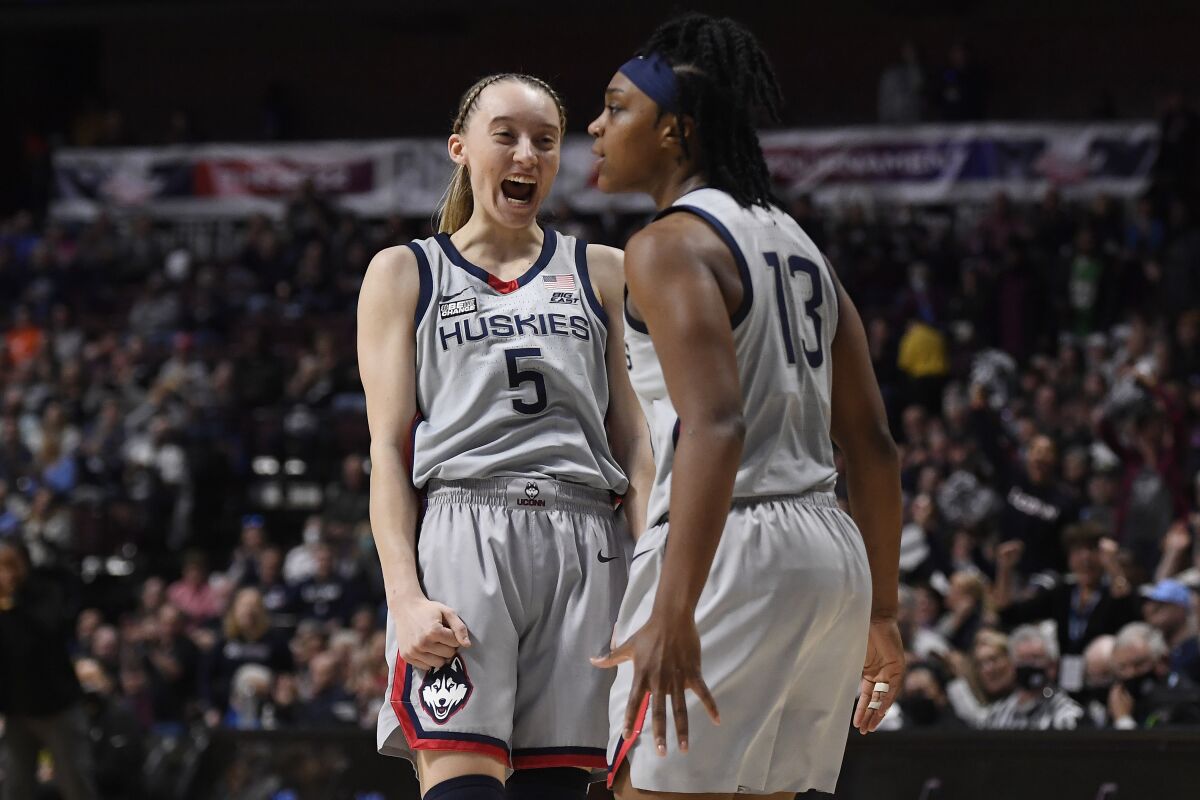 Connecticut's Paige Bueckers (5) reacts toward teammate Christyn Williams in the first half of an NCAA college basketball game against Marquette in the Big East tournament semifinals at Mohegan Sun Arena, Sunday, March 6, 2022, in Uncasville, Conn. (AP Photo/Jessica Hill)