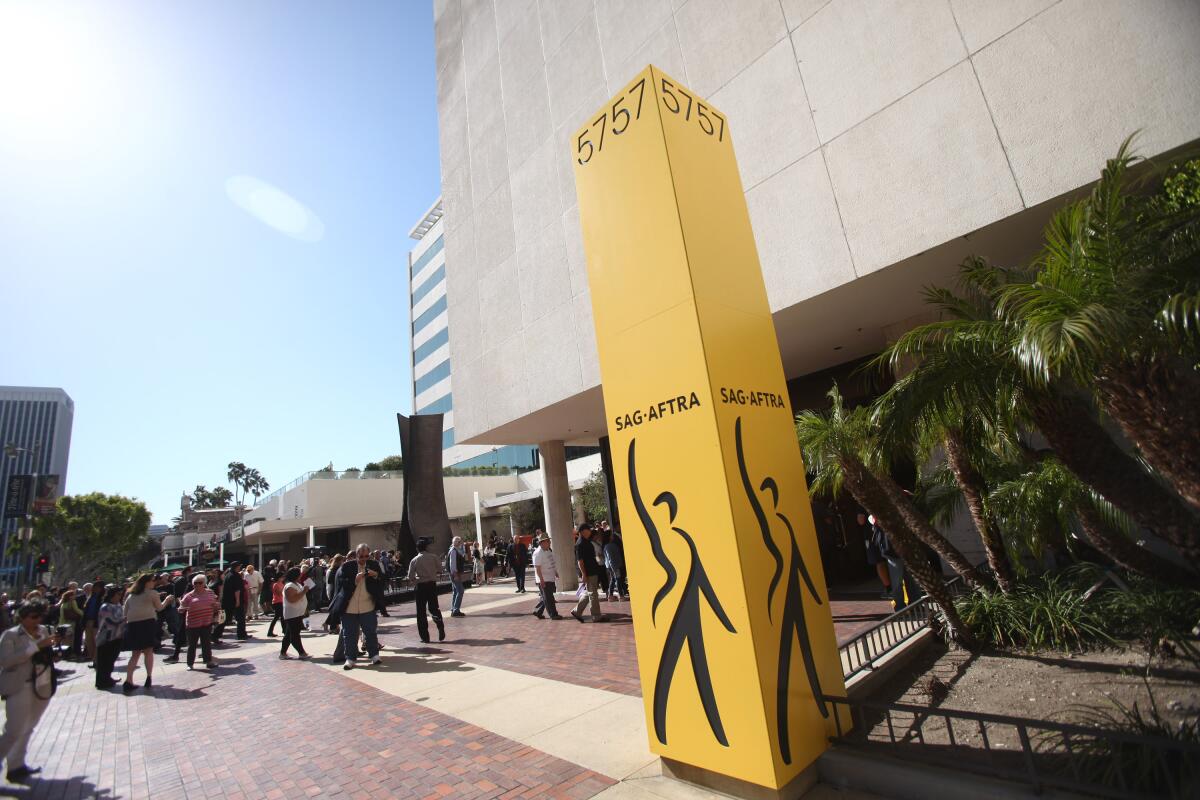 A yellow pillar with the number "5757" and the letters "SAG-AFTRA" appears in front of a building.