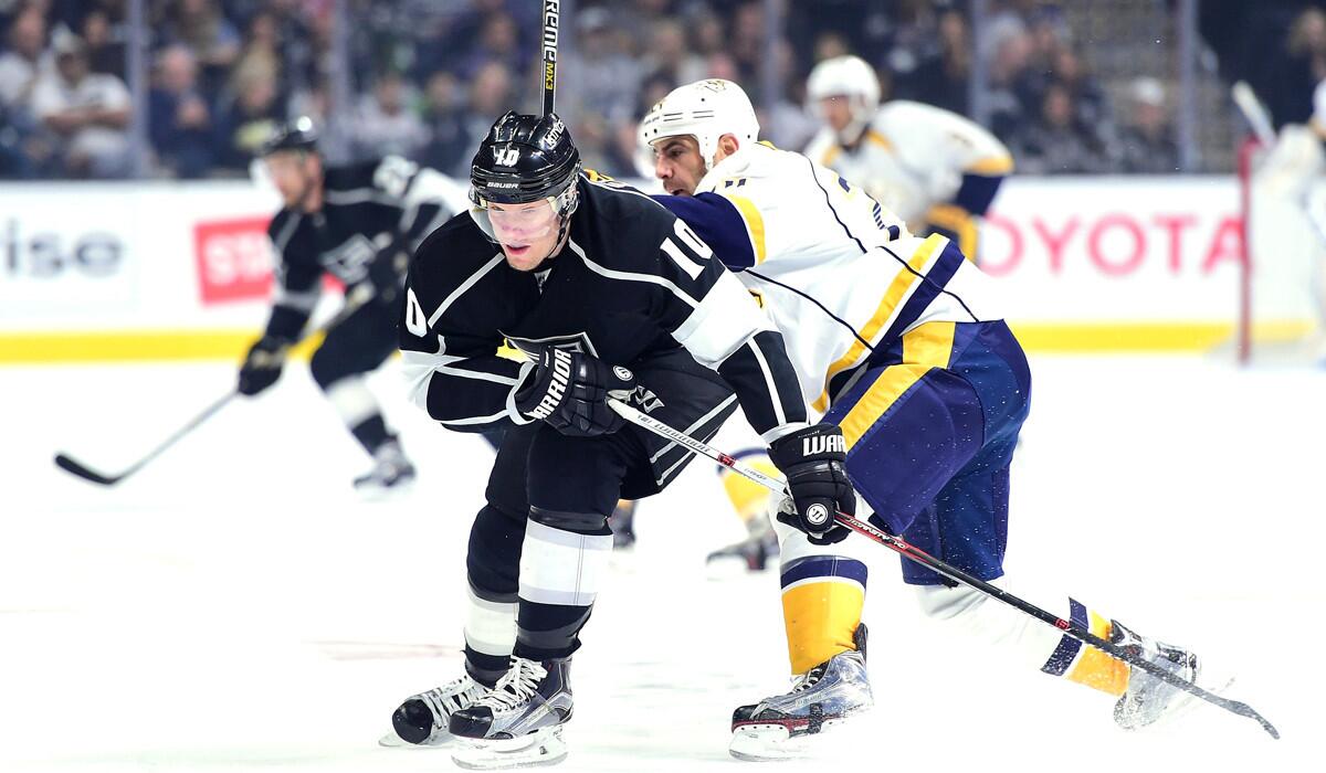 Kings' Christian Ehrhoff, left, turns away from a check by Nashville Predators' Eric Nystrom during the first period at Staples Center on Saturday.