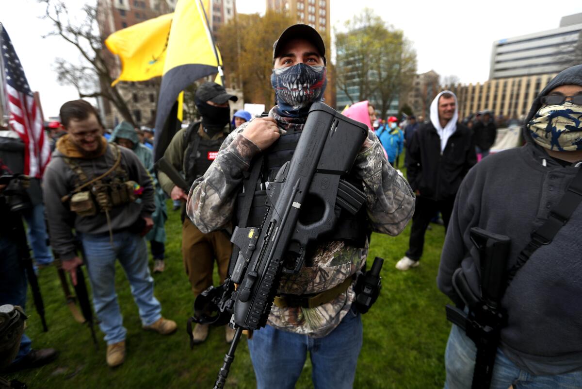 A  protester carries a rifle at the State Capitol in Lansing, Mich., in April.  