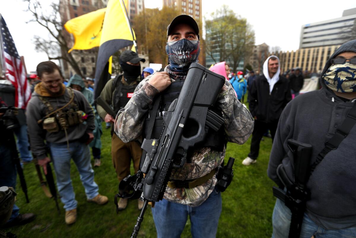 A protester carries a rifle at the State Capitol in Lansing, Mich., in April.