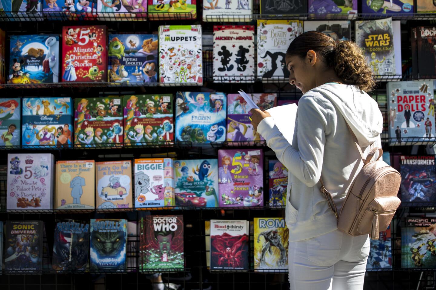 LOS ANGELES, CALIF. - APRIL 21: Esmeralda Oieda, 15, of Bakersfield looks at books during the annual Los Angeles Times Festival of Books on Saturday, April 21, 2018 in Los Angeles, Calif. (Kent Nishimura / Los Angeles Times)