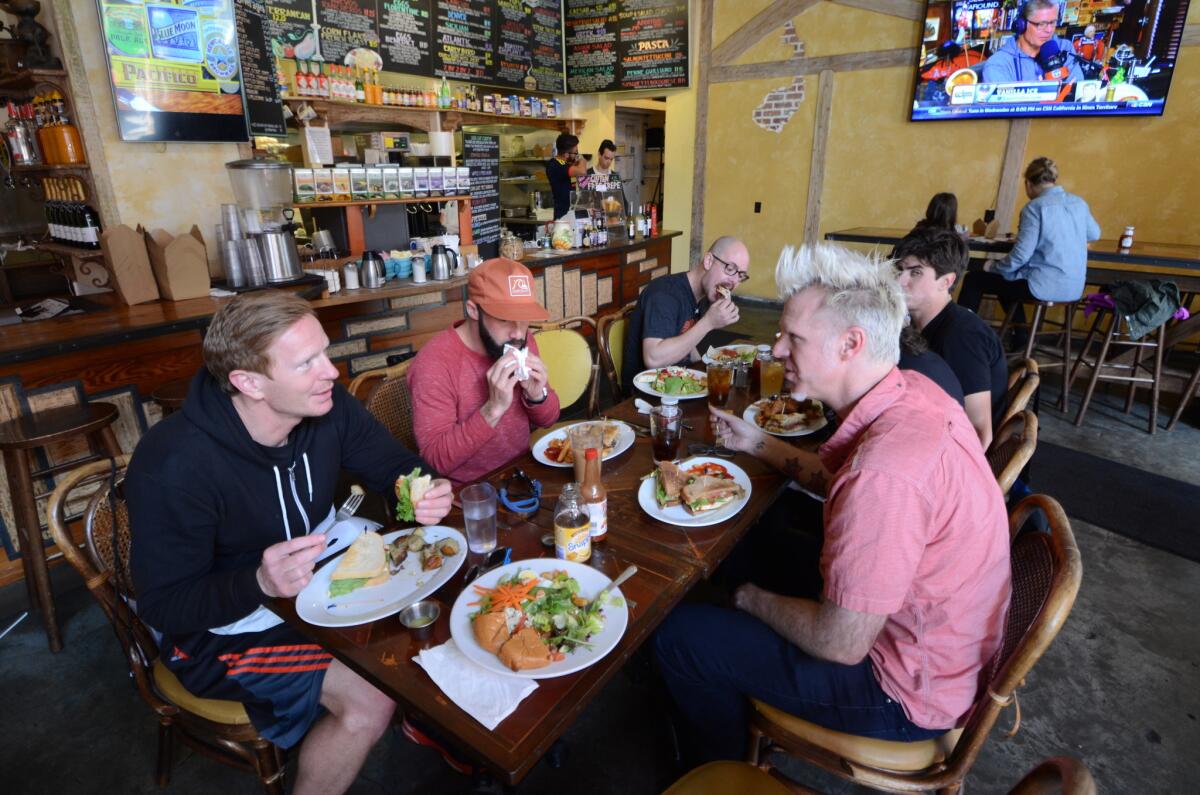 Guide Jefferson McCarley, right, chats with earthquake tour riders at the Crepe House Restaurant in San Francisco.