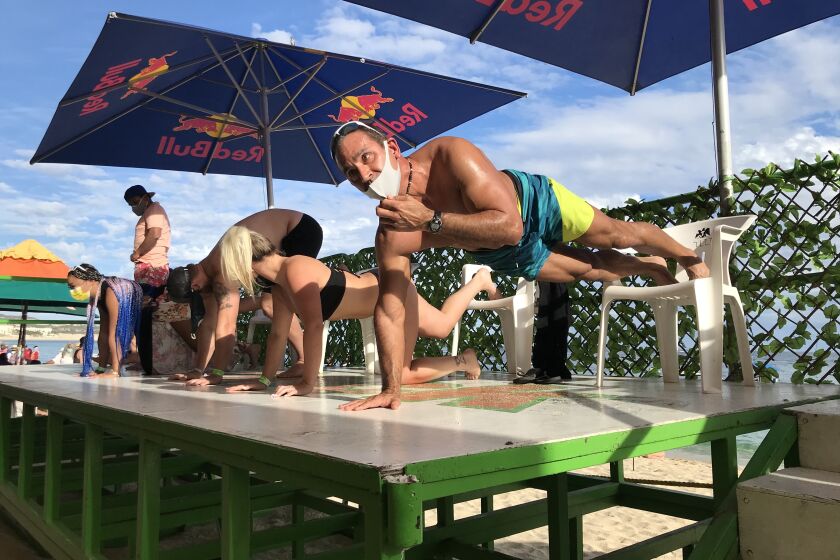 A push-up competition Dec 8 at Mango Deck, a beach bar in Cabo San Lucas, competitors were required to begin with masks, but many quickly fell off.