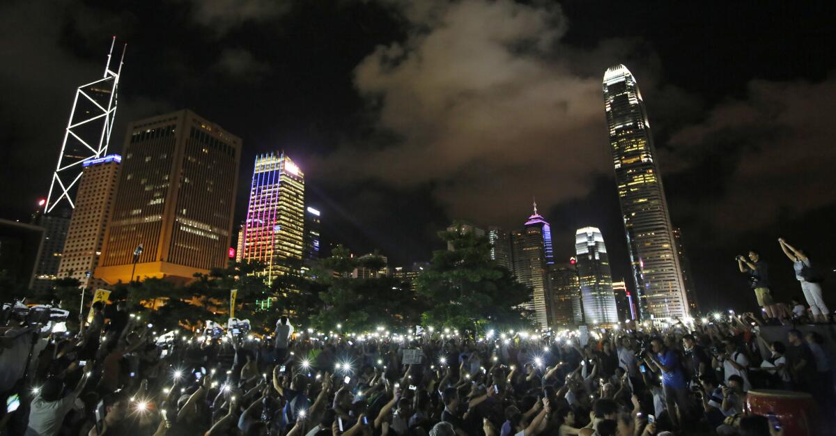 Pro-democracy protesters wave their mobile phones during a rally Sunday night in Hong Kong after China's legislature ruled out open nominations in elections for the territory's next leader.
