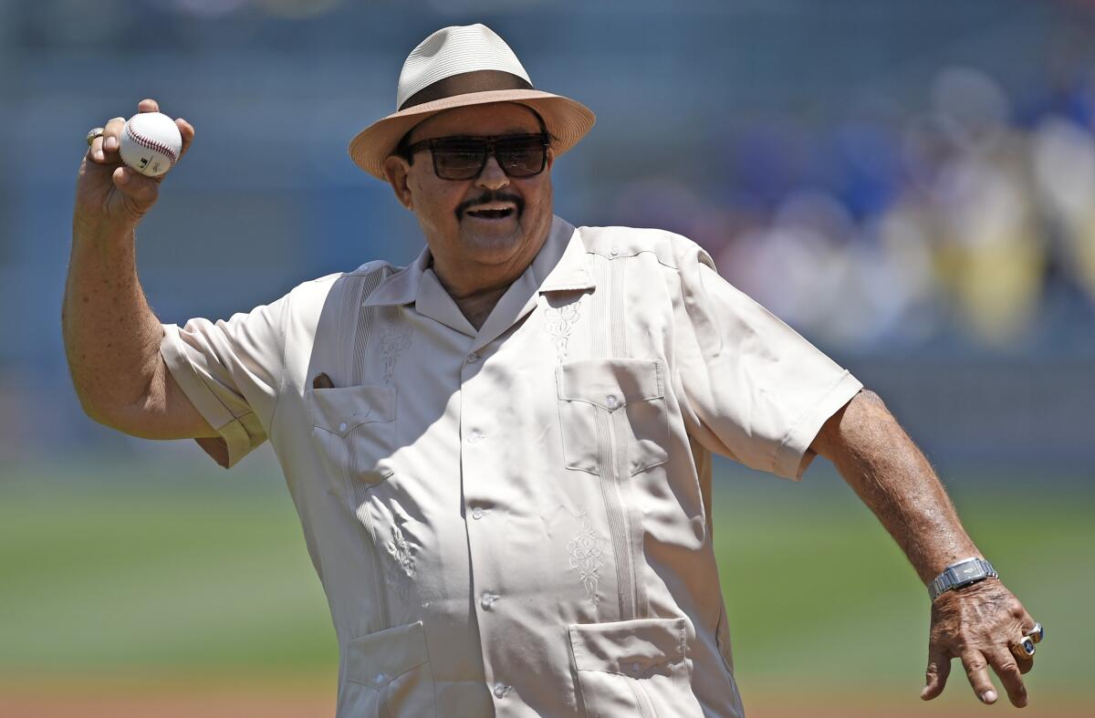 Dodgers scout Mike Brito throws out the first pitch prior to a baseball game between the Dodgers and Rockies