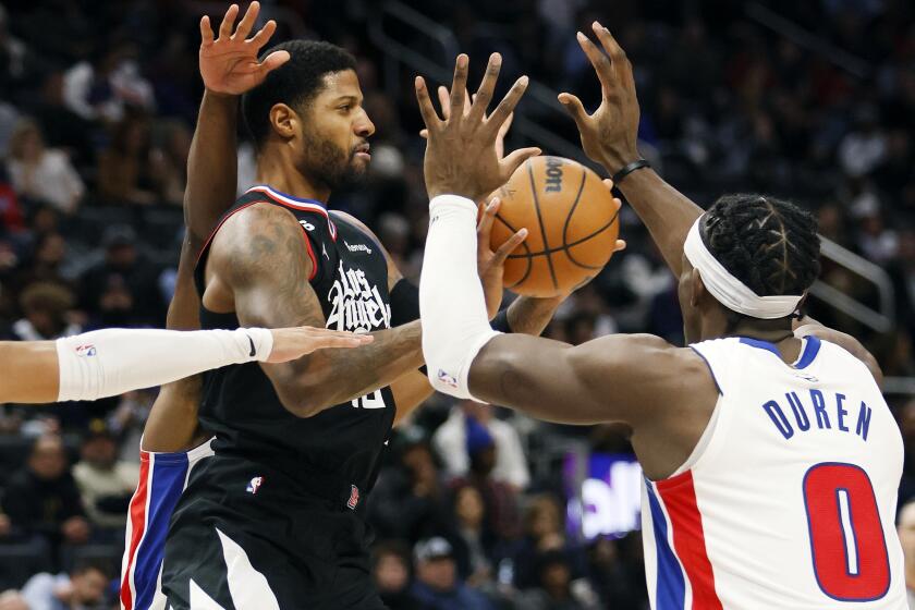 Los Angeles Clippers guard Paul George passes the ball against Detroit Pistons center Jalen Duren (0) during the first half of an NBA basketball game, Monday, Dec. 26, 2022, in Detroit. (AP Photo/Duane Burleson)