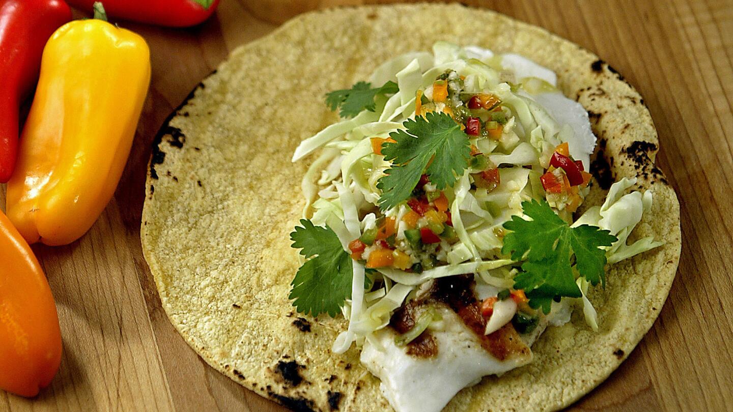 Pile the fish into warm tortillas with plenty of shredded cabbage and a fresh tangy lime-garlic vinaigrette.