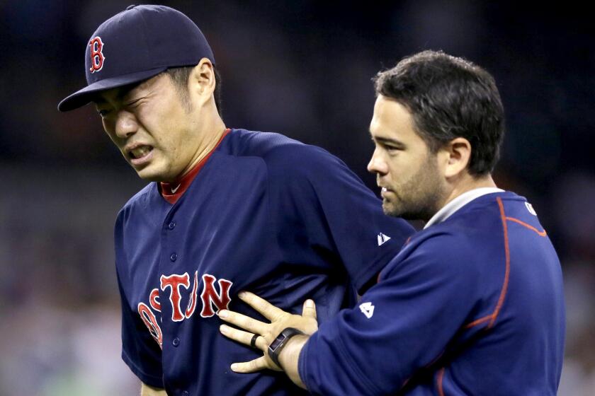 Red Sox relief pitcher Koji Uehara is helped off the field after a groundball hit by Detroit's Ian Kinsler struck him in the the right wrist on Friday.