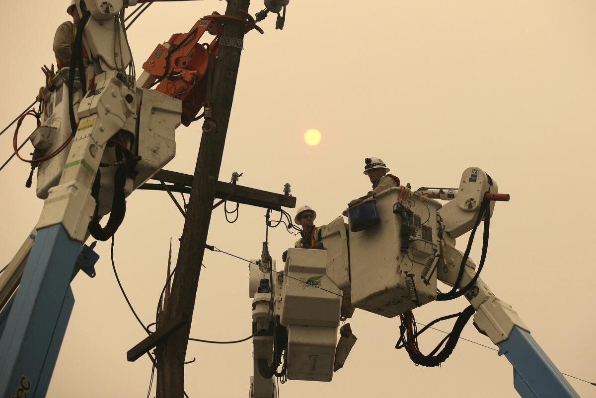 Pacific Gas & Electric crews work to restore power lines in Paradise