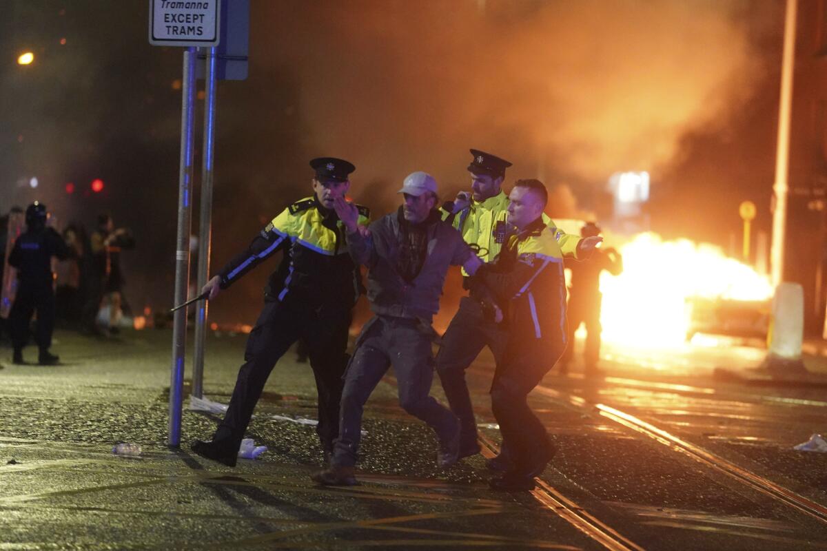 Irish police taking away a man after riot