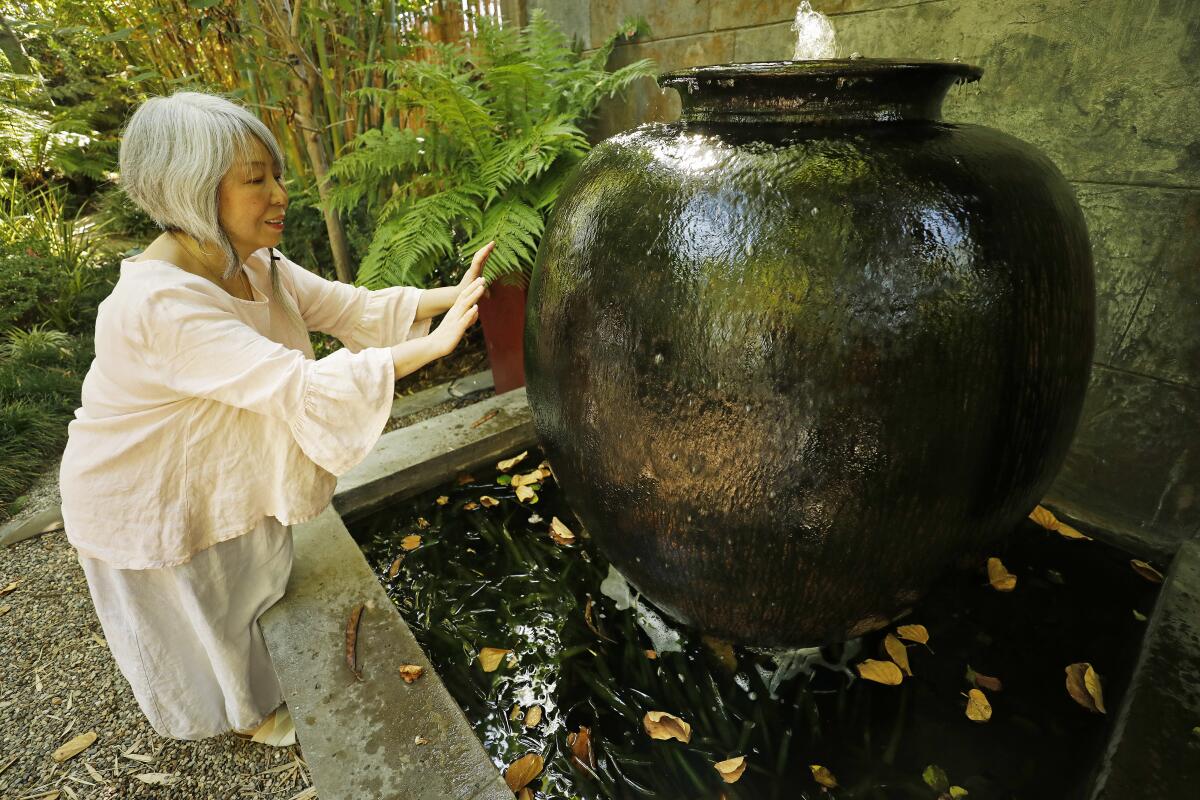 Sung-Eun Lee reacts with a water feature at meditation gardens
