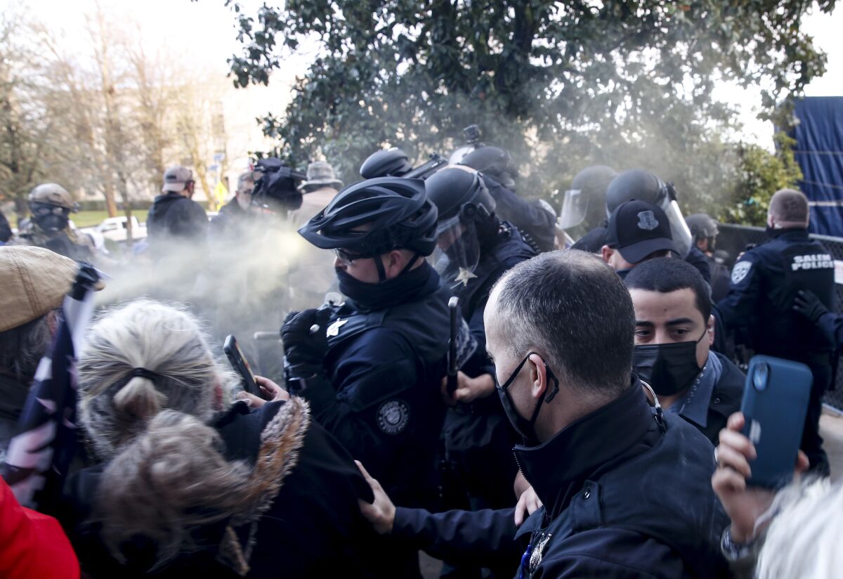 Protesters spray Mace at police as they attempt to get into the Oregon State Capitol in Salem on Monday.
