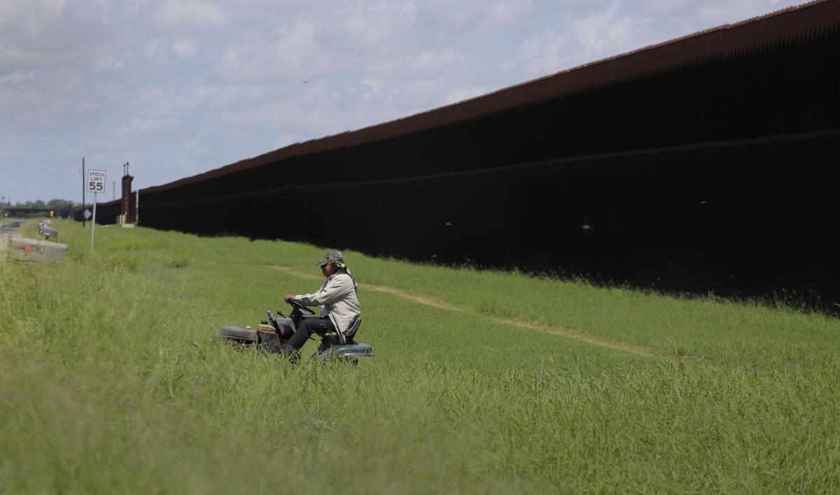 A man mows his property along the border fence in Brownsville, Texas in September of 2015.