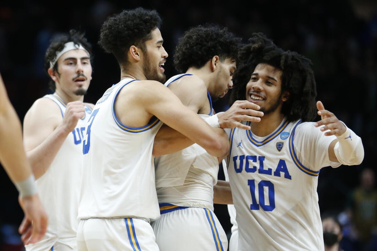 UCLA players, including guard Tyger Campbell, celebrate they beat Akron in the NCAA tournament.