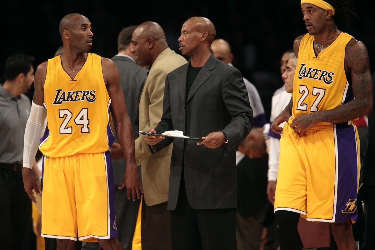 Lakers Coach Byron Scott chats with guard Kobe Bryant (24) during a timeout.