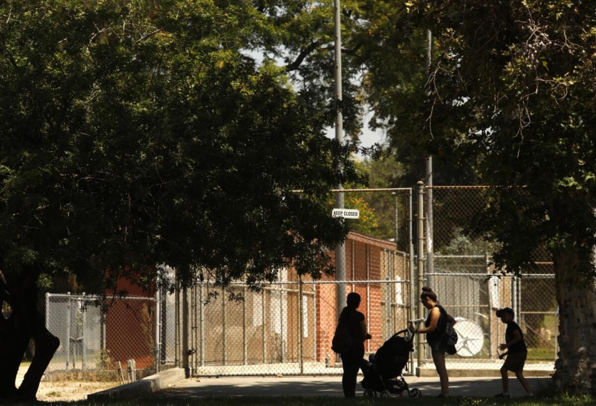 La gente visita el parque Valley Plaza en North Hollywood, cerca de donde un hombre sin hogar fue asesinado este año como parte de un intento por reclamar territorio de la pandilla Fulton de los MS-13.(Genaro Molina / Los Angeles Times)