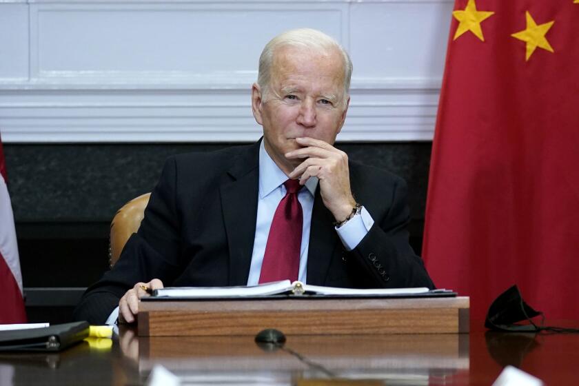 FILE - President Joe Biden listens as he meets virtually with Chinese President Xi Jinping from the Roosevelt Room of the White House in Washington,Nov. 15, 2021. The Biden administration announced on Thursday that it is levying new sanctions against several Chinese biotech and surveillance companies operating out of Xinjiang province, casting another shot at Beijing over human rights abuses against Uyghurs in western China. (AP Photo/Susan Walsh, File)